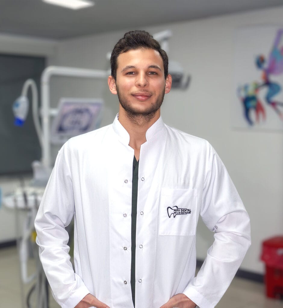 Dt. Ahmet Çiçek, MRV Dental Antalya kliniğinde beyaz önlüğüyle poz veren diş hekimi portresi