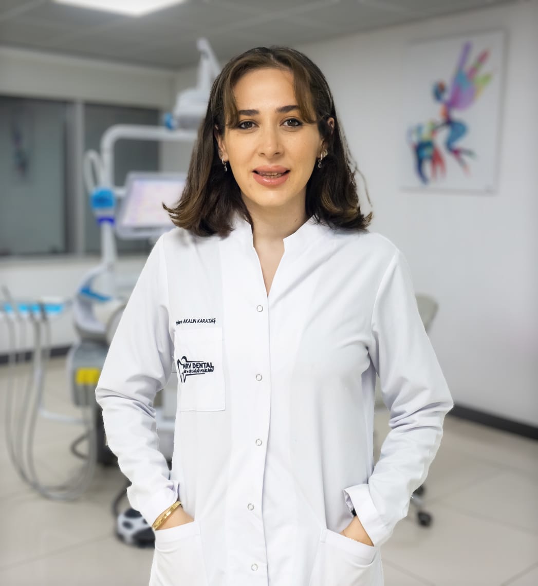 Dt. Merve Akalın Karataş, MRV Dental Antalya kliniğinde profesyonel bir duruşla gülümseyen diş hekimi